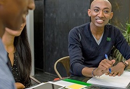 A TD colleague smiles while participating in a group meeting.